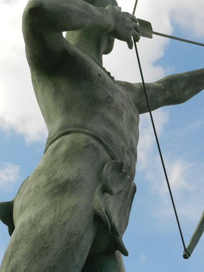 Close-up of McPherson Ad Astra figure's torso from the side, showing from below the hip to the shoulders, with a bowstring visible in the side of the image.